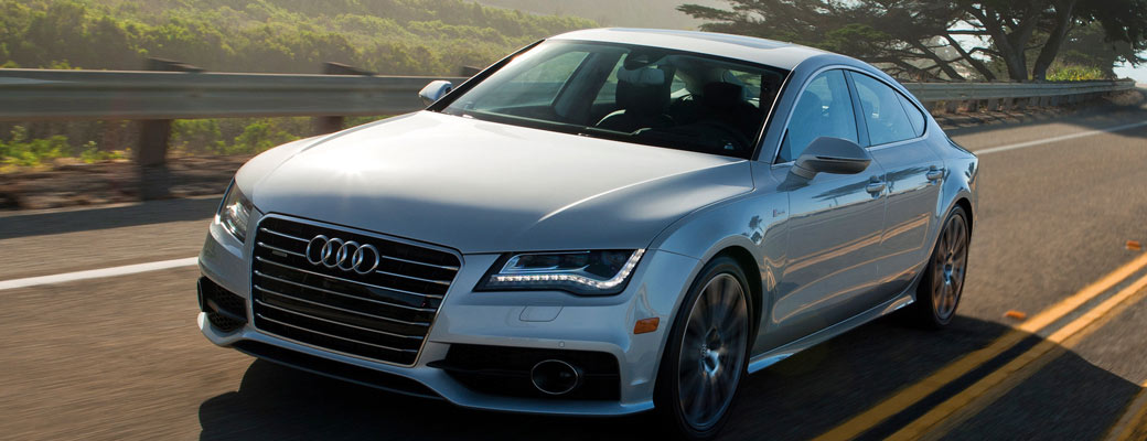 White Audi sedan driving coastal highway